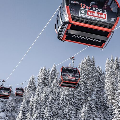 Red mountain railway gondolas in a snowy winter landscape