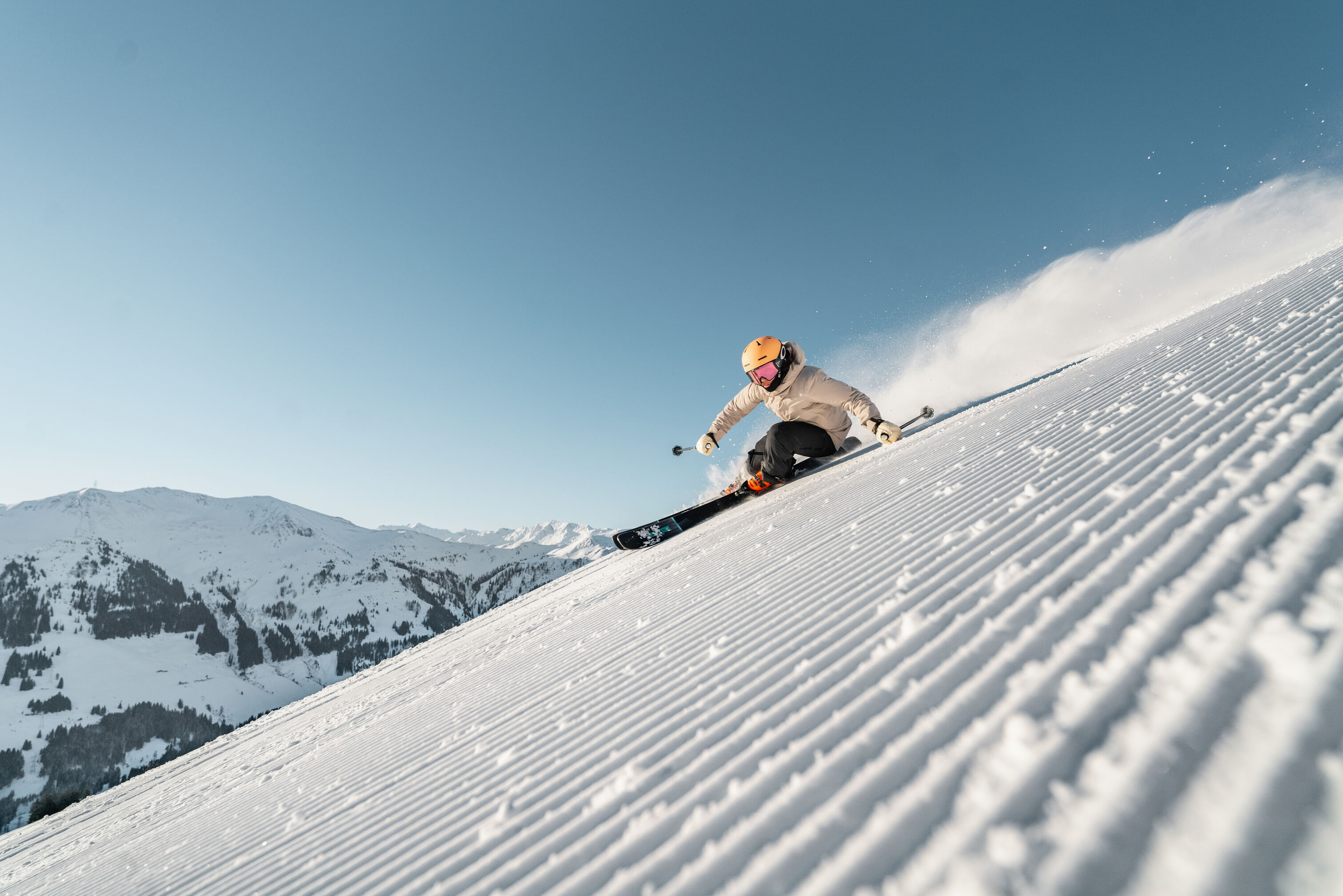 Skifahrer fährt über perfekt präparierte Piste in den Alpen