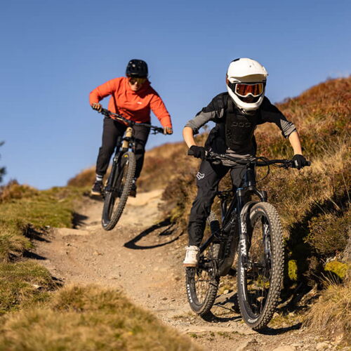 Zwei Downhiller auf einem Trail in den Alpen