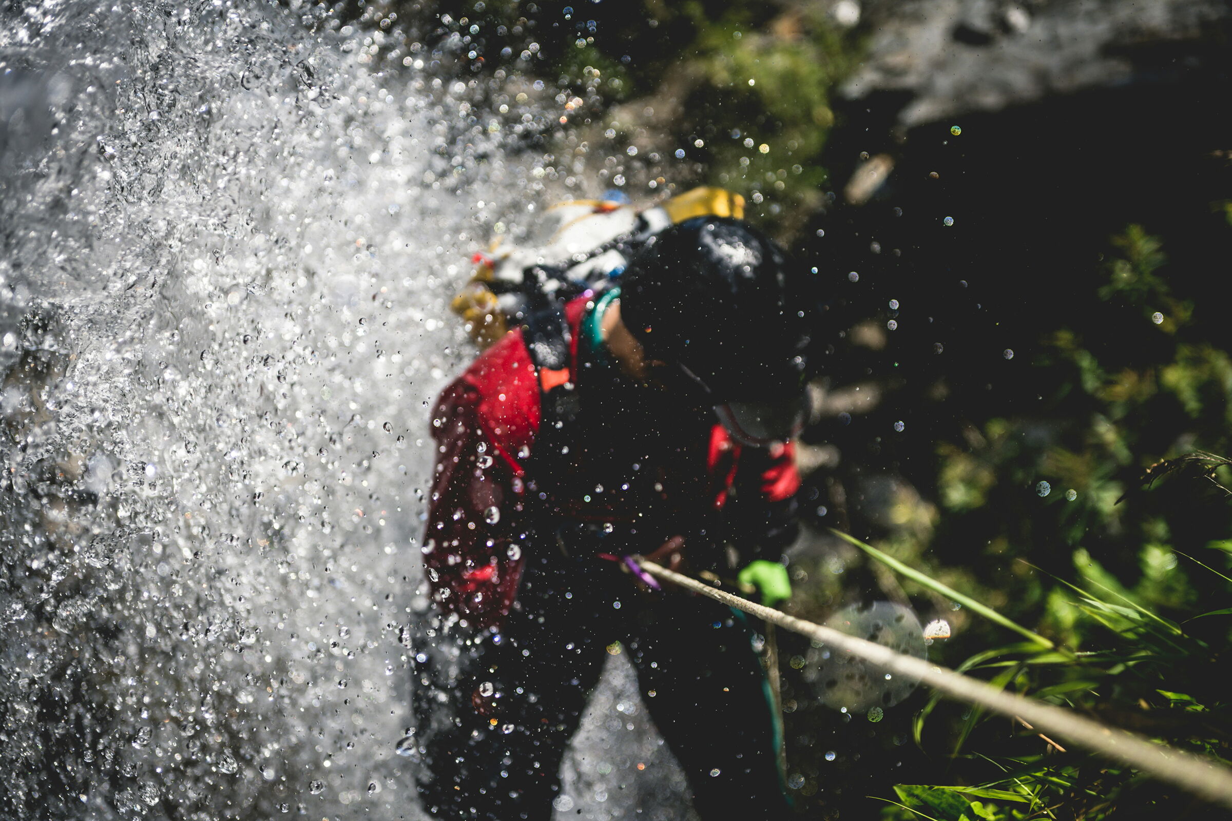Mann beim Canyoning ist an einem Seil gesichert