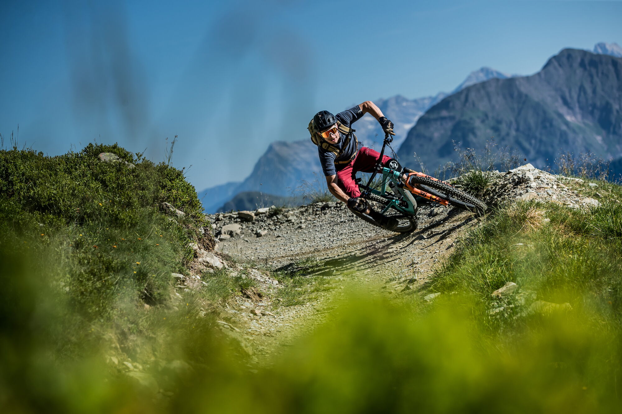Ein Mountainbiker fährt bei schönem Wetter einen Trail in Hinterglemm