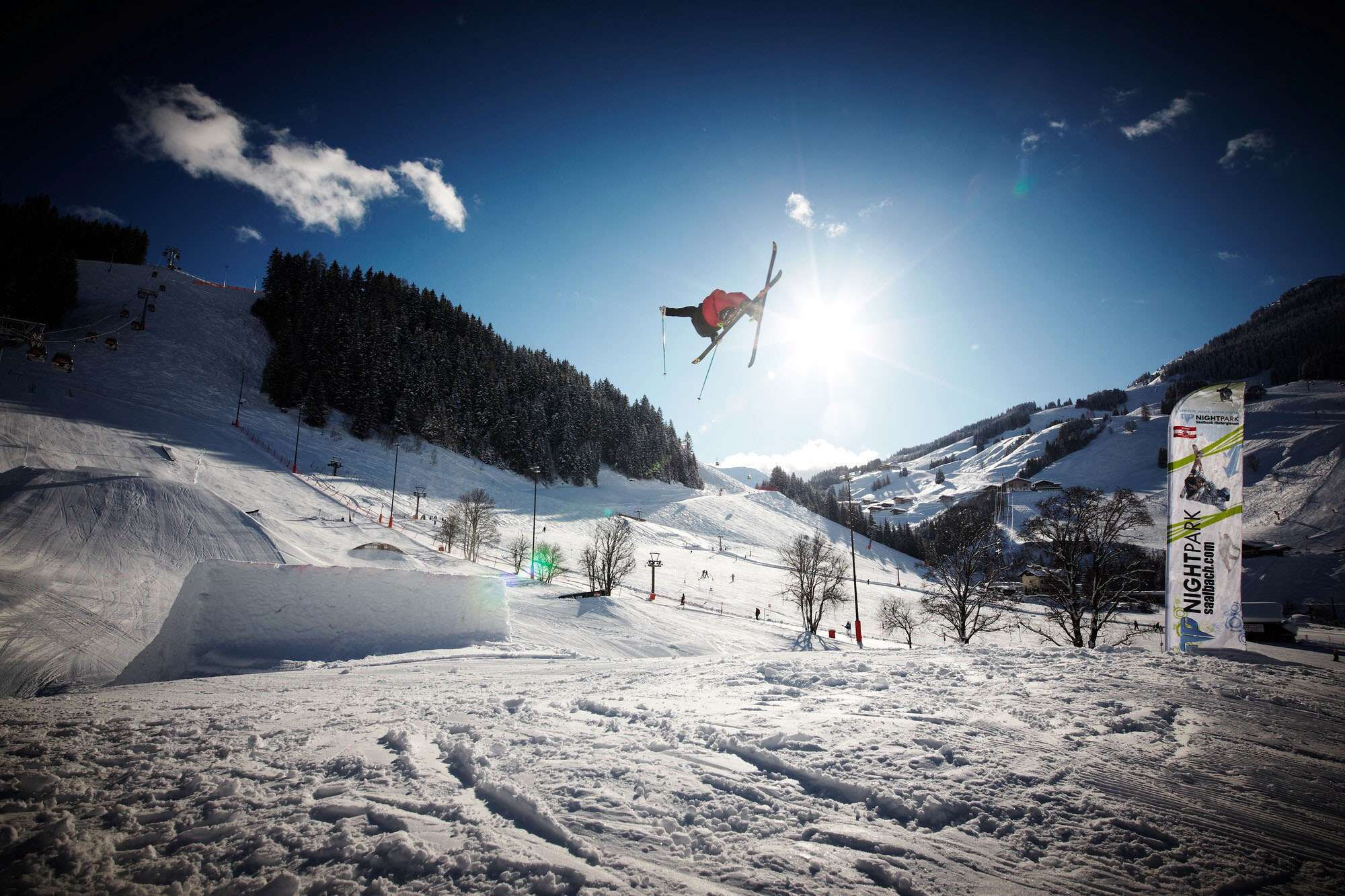 Im Funpark springen mutige Skifahrer über eine Sprungschanze