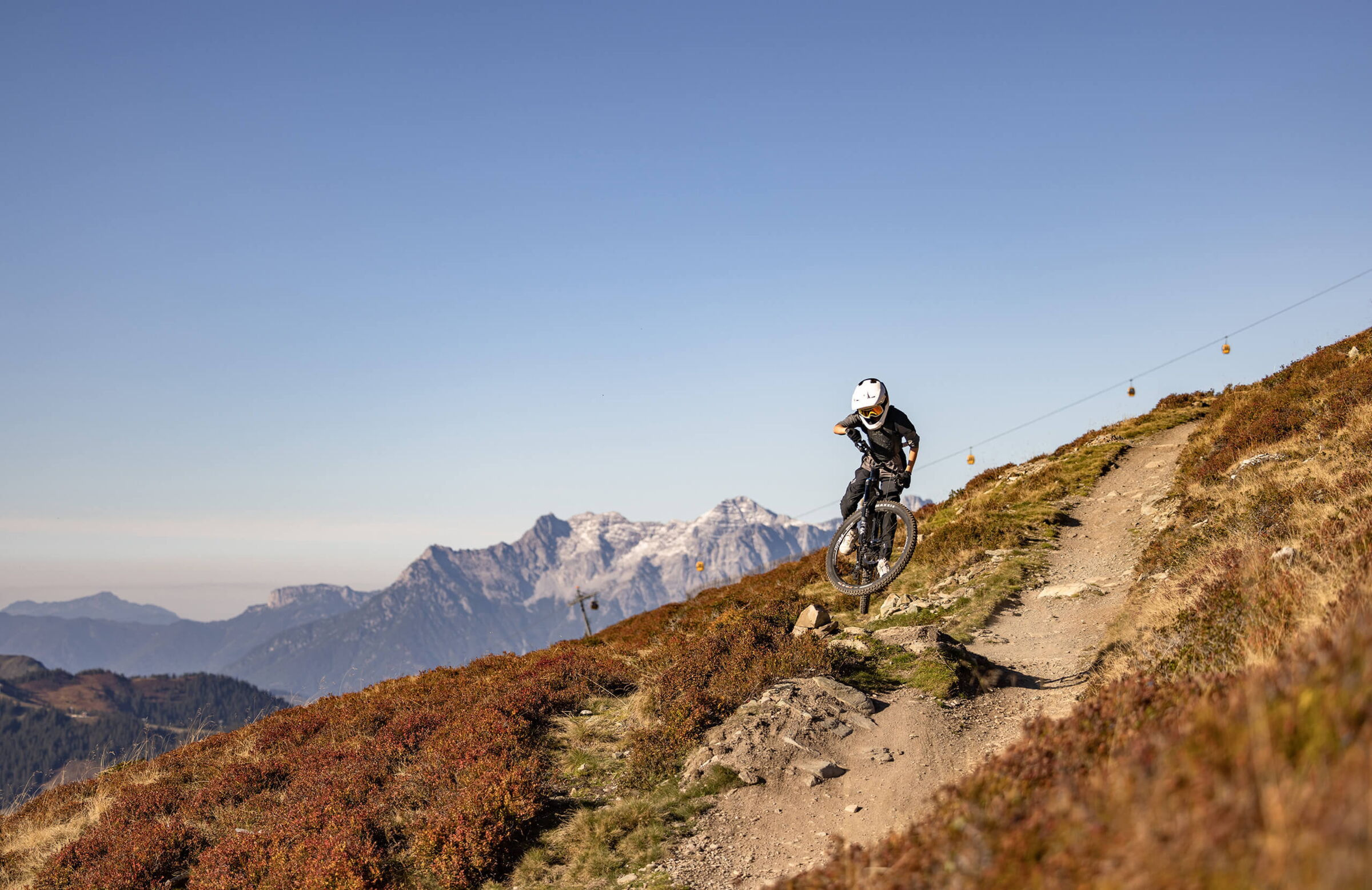 Mountainbiker im Sprung auf einen Trail in Saalbach Hinterglemm