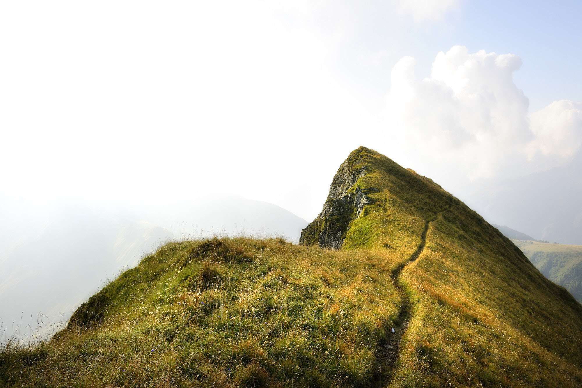 Ein schmaler Weg führt zu einer kleinen Bergspitze in Hinterglemm
