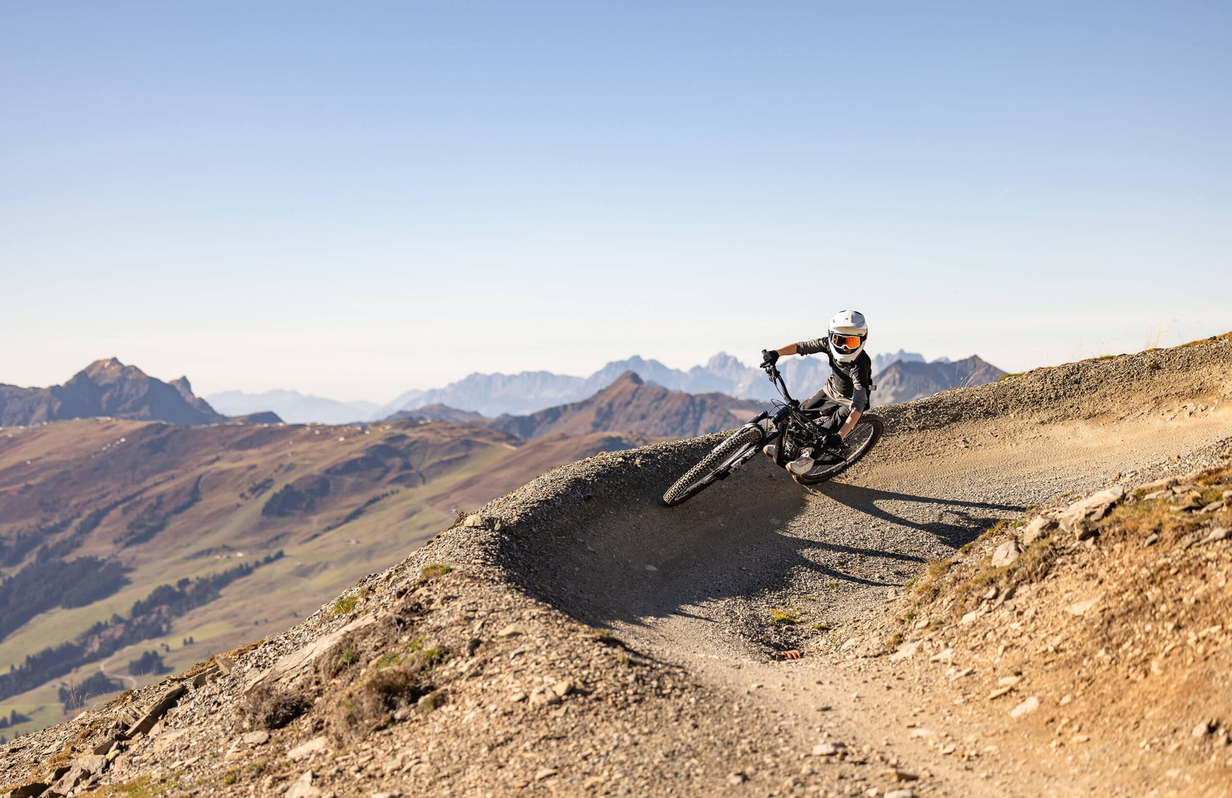 Mountainbiker bei der abfahrt auf einer Schotterstraße in den Alpen Salzburgs