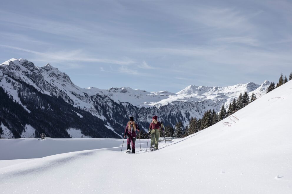 Zwei Menschen beim Schneeschuhwandern in den Bergen