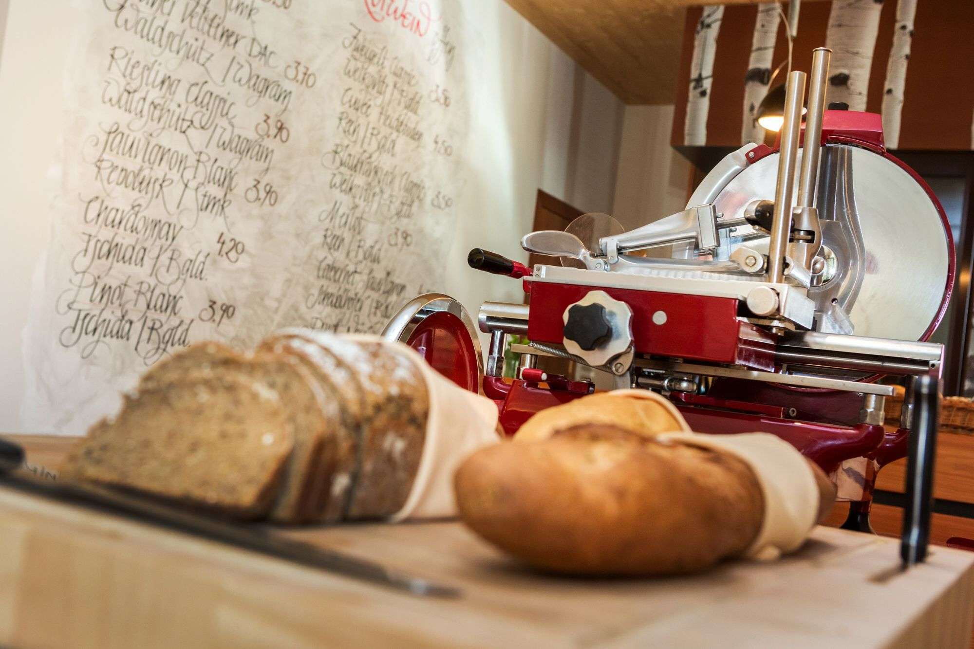Brotsorten beim Frühstücksbuffet neben der Brotschneidemaschine